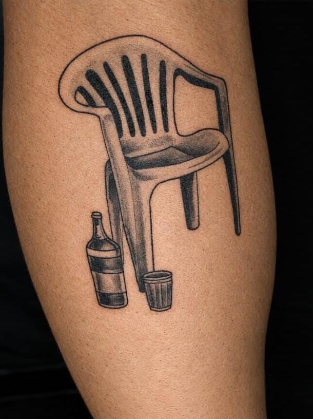 Tatuagem em preto e cinza de cadeira de plástico com garrafa e copo
